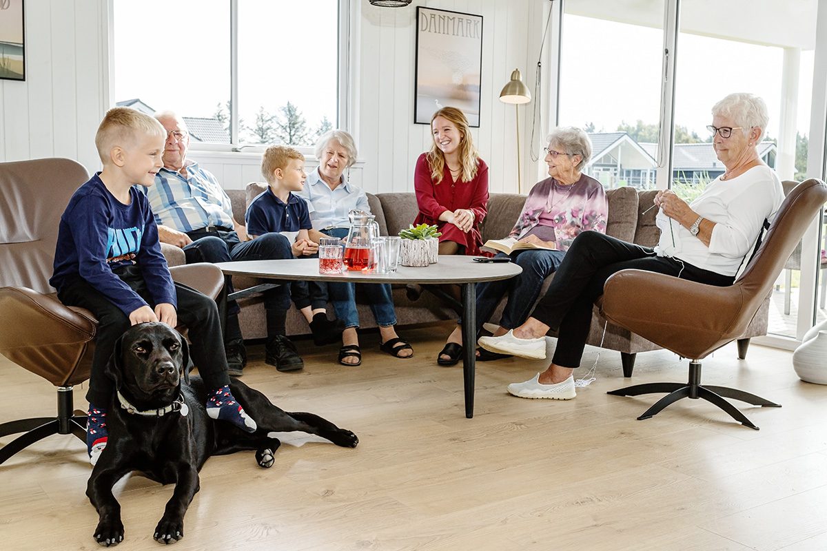 Eine Familie mit ihrem Hund vor einem Ferienhaus, ideal für einen Urlaub mit Vierbeiner.