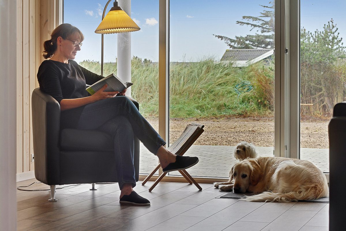 Hund sitzt am Kamin in einem luxuriösen dänischen Ferienhaus