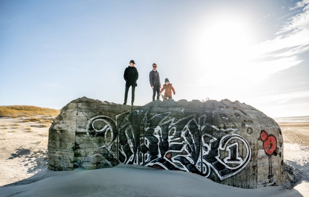 Familie auf einem alten Bunker in Dänemark mit Graffiti.