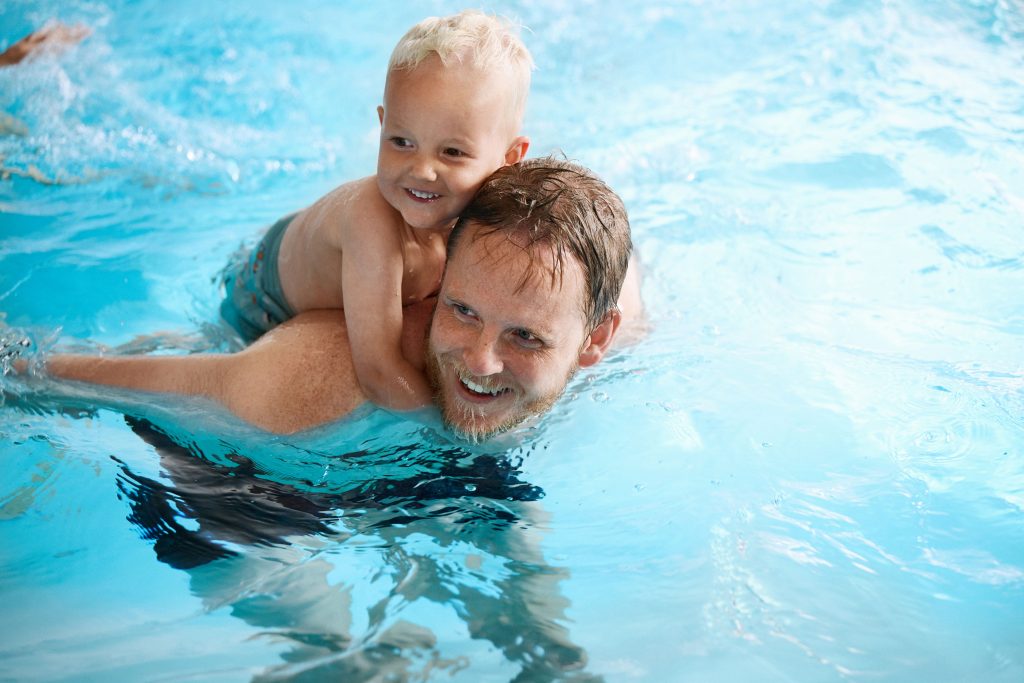Vater und Sohn im Swimmingpool im Ferienhaus